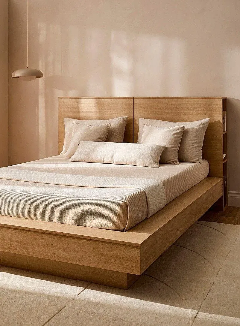 Cama de tarima ancha en madera miel con cabecero de panel y repisa lateral