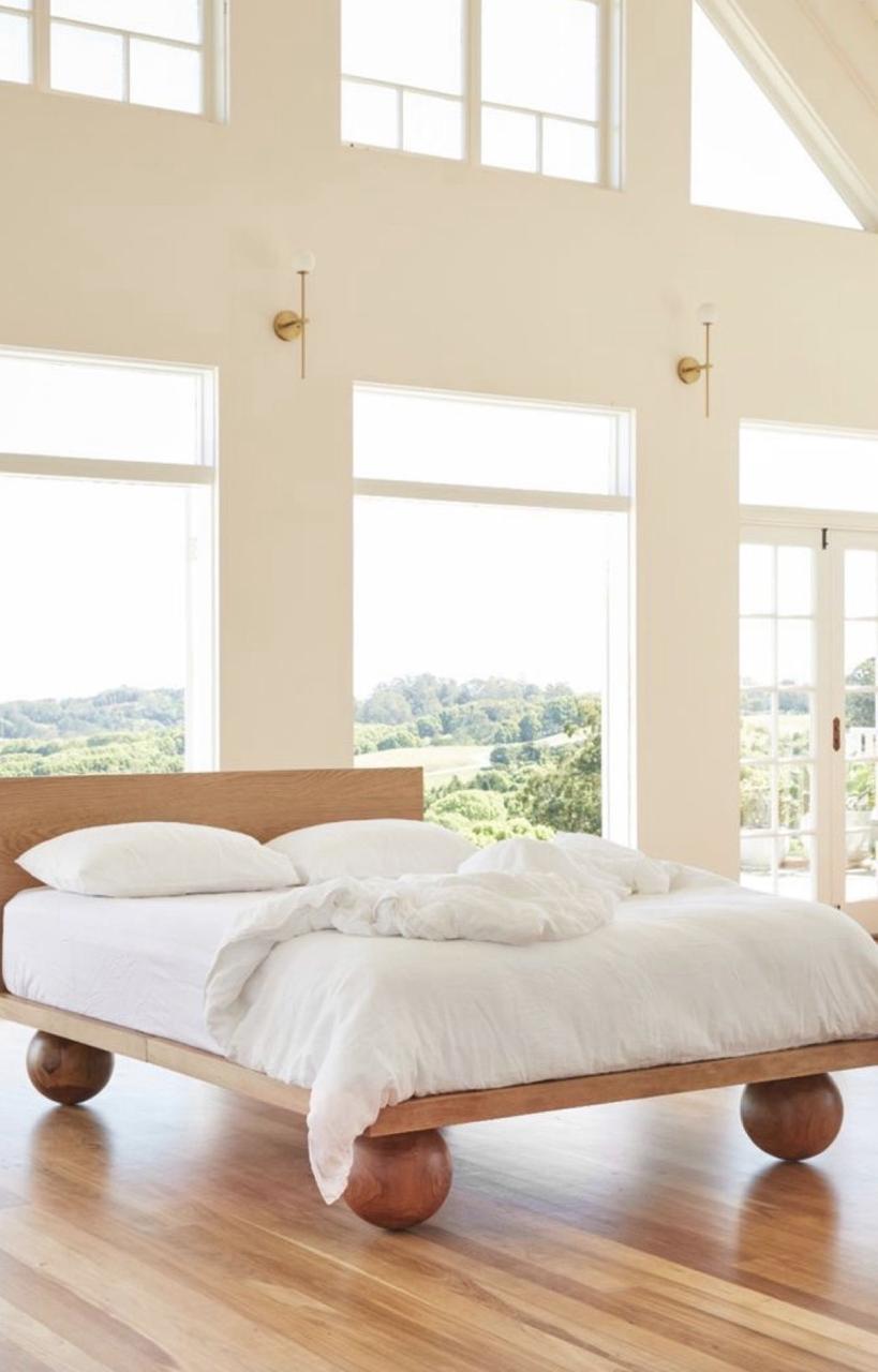 Cama de tarima con cuatro esferas de madera como patas